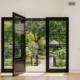 Open black framed glass doors leading from a living room to a garden patio Los Angeles