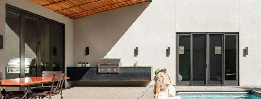 Stylish replacement doors in Los Angeles, CA, complement a modern home with expansive glass, dark frames, and scenic outdoor views.